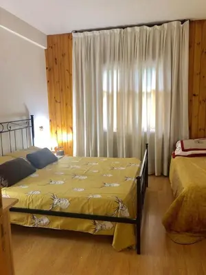 a bedroom with two beds and a window with curtains at Appartamento AB in Passo San Pellegrino