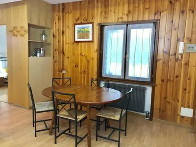 a dining room with a table and chairs and a window at Appartamento AB in Passo San Pellegrino