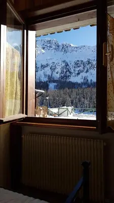 a window with a view of a snow covered mountain at Appartamento AB in Passo San Pellegrino