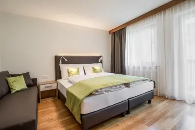 a bedroom with a large bed and a window at Ciasa MAEL Dolomites Apartments in La Valle