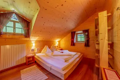 a bedroom with a bed in a wooden cabin at Prackfiedererhof in Villandro