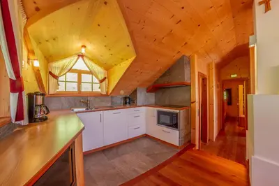 a kitchen with white cabinets and a wooden ceiling at Prackfiedererhof in Villandro