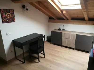 a room with a black desk and a table at Casa Renzo - Dolomiti - Trentino in Mezzano