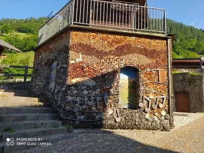 a brick building with a balcony on top of it at Casa Renzo - Dolomiti - Trentino in Mezzano