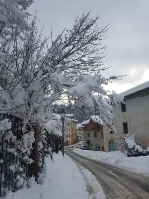 a street covered in snow with trees and buildings at Agritur Coryletum in Coredo