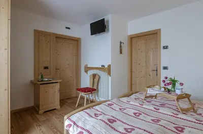 a bedroom with a bed and a table and a chair at Agritur Coryletum in Coredo