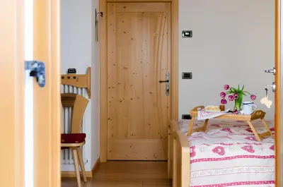 a bedroom with a bed and a wooden door at Agritur Coryletum in Coredo