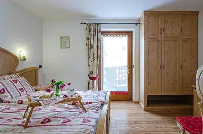 a bedroom with a bed and a window and a table at Agritur Coryletum in Coredo