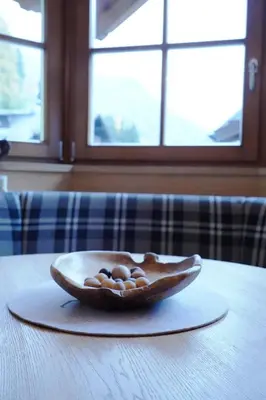a bowl of nuts on a plate on a table at Grohmann Apartments in Selva di Val Gardena