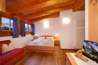 a large room with two beds and a couch at Grohmann Apartments in Selva di Val Gardena