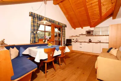 a kitchen and dining room with a table and chairs at Grohmann Apartments in Selva di Val Gardena