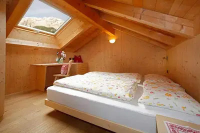 a bedroom with a bed in a attic at Grohmann Apartments in Selva di Val Gardena
