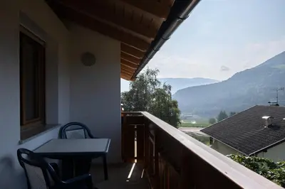 a balcony of a house with a table and chairs at Fewo Dreiraum im Haus Götsch 6 in Parcines