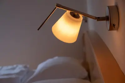 a lamp on a wall next to a bed at Fewo Dreiraum im Haus Götsch 6 in Parcines