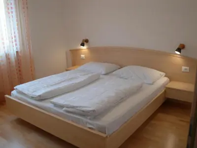 a bed with white sheets and pillows in a bedroom at Fewo Dreiraum im Haus Götsch 6 in Parcines