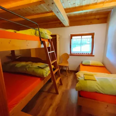 a room with two bunk beds and a ladder at Rifugio Stella Alpina Spiz Piaz per escursionisti in Gardeccia - San Giovanni di Fassa