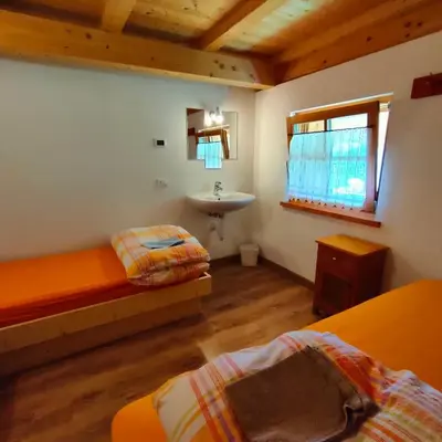 a room with two beds and a sink in it at Rifugio Stella Alpina Spiz Piaz per escursionisti in Gardeccia - San Giovanni di Fassa