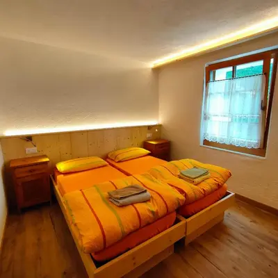 a bedroom with a bed with two bags on it at Rifugio Stella Alpina Spiz Piaz per escursionisti in Gardeccia - San Giovanni di Fassa