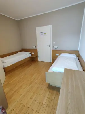 a small room with two beds and a cabinet at Garni Maria in Varna
