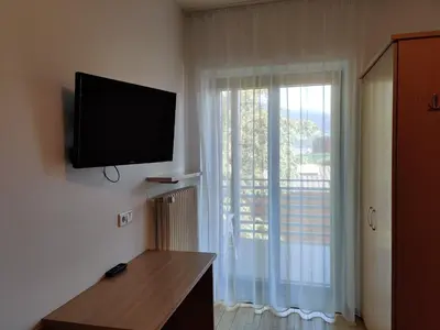 a room with a flat screen tv on a wall with a window at Garni Maria in Varna