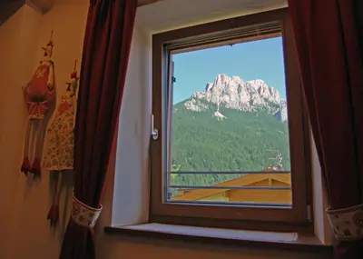 a window with a view of a mountain at Ciasa Sas da le Doudesc in Vigo di Fassa