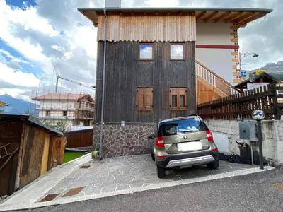 a small car parked in front of a house at Ciasa Sas da le Doudesc in Vigo di Fassa