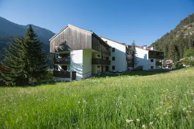 a building on a hill with a field of grass at Sass Pordoi in Mazzin