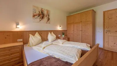 a bedroom with a large bed in a room with wooden ceilings at Agriturism Gscnara in San Martino in Badia