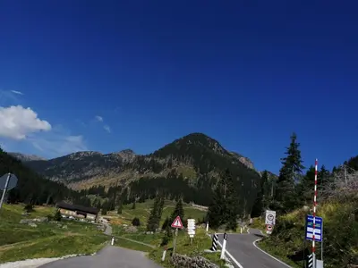 a road in the mountains with a blue sky at B&B PRA' DEI CERVI in Telve