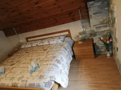 a bedroom with a bed and a wooden wall at B&B PRA' DEI CERVI in Telve