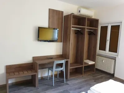 a room with a desk and a tv on a wall at Roma Ariston 8 in Bolzano