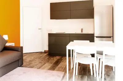 a kitchen with a white table and white chairs at Roma Ariston 8 in Bolzano