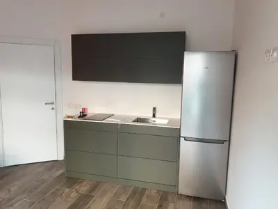 a kitchen with a stainless steel refrigerator and a sink at Roma Ariston 8 in Bolzano