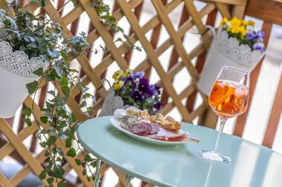 a plate of food and a glass of wine on a table at Maison Valentina in Merano