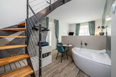 a bathroom with a bath tub and a staircase at Maison Valentina in Merano