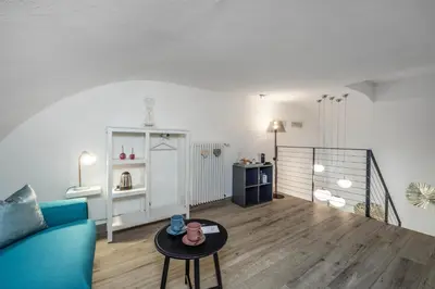 a living room with a blue couch and a table at Maison Valentina in Merano