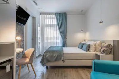 a hotel room with a bed and a tv at Maison Valentina in Merano