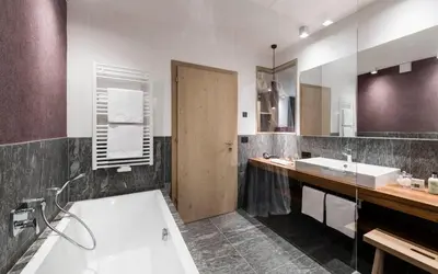 a bathroom with a tub and a sink at Vinea - Suites in Tirolo