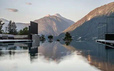 a swimming pool with a view of a mountain at Vinea - Suites in Tirolo