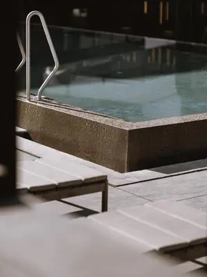 a swimming pool with a bench in front of it at Lindenhof Pure Luxury & Spa DolceVita Resort in Naturno