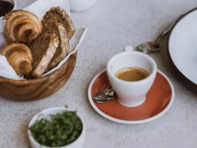 a bowl of bread and a cup of coffee on a table at Lindenhof Pure Luxury & Spa DolceVita Resort in Naturno