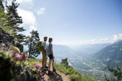 two people standing on a hill looking at a valley at Lindenhof Pure Luxury & Spa DolceVita Resort in Naturno