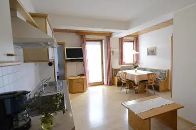 a kitchen and living room with a table and a kitchen and a dining room at Residence Badleit in Lagundo