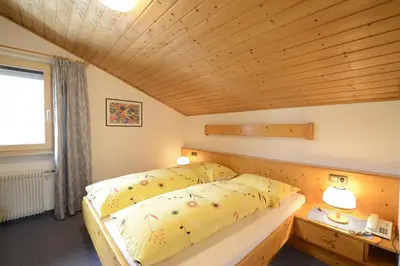 a bedroom with a bed and a wooden ceiling at Residence Badleit in Lagundo