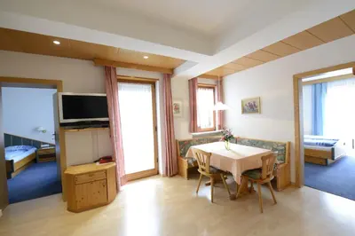 a room with a table and chairs and a bedroom at Residence Badleit in Lagundo