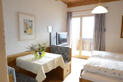 a hotel room with a table and a bed and a window at Residence Badleit in Lagundo