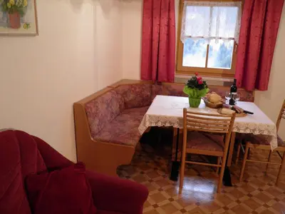 a living room with a table and a couch and a table and chair at Flatscherhof in San Lorenzo di Sebato