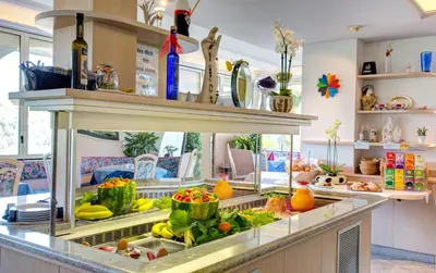 a kitchen with a refrigerator filled with fruits and vegetables at Hotel Weinberg in Appiano sulla Strada del Vino