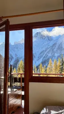 a room with a window with a view of mountains at IL COVO DELLO SCIATORE in Falcade