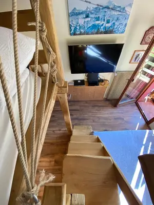 a staircase in a room with a bed and a tv at IL COVO DELLO SCIATORE in Falcade